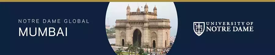 Gateway of India in Mumbai, a large sandstone arch monument with turrets, bustling with people, located near the water.